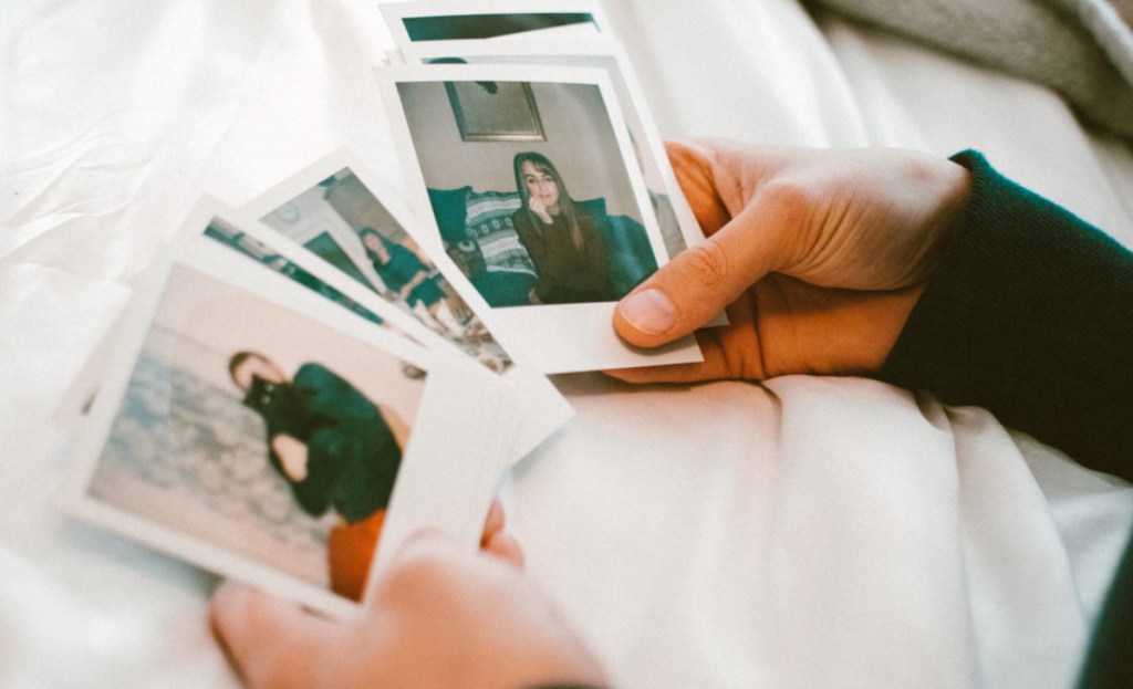 A person holding several Polaroid pictures in their hand, displaying captured memories.