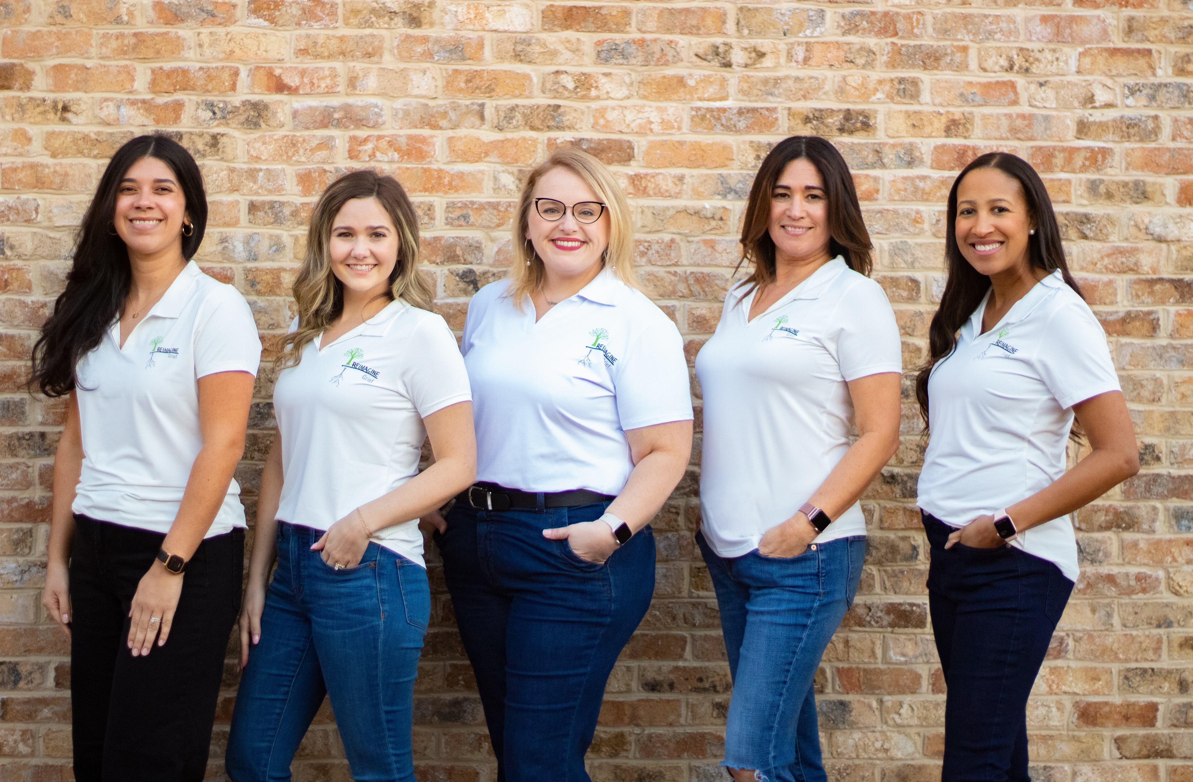 Five Reimagine Grief staff members standing together, smiling and ready to assist with the needs of children and families
